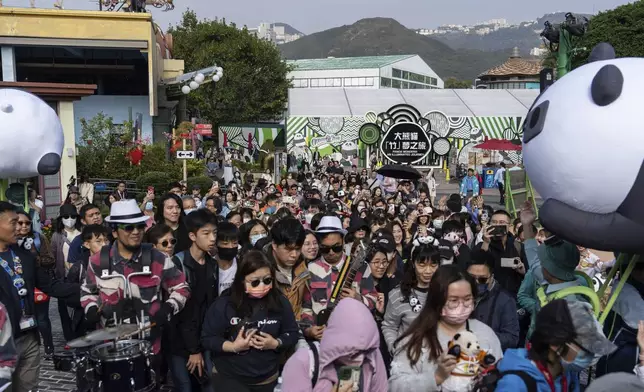 Visitors enter the panda enclosure to meet the Hong Kong-born giant panda twin cubs as they make their debut appearance to public in Ocean Park in Hong Kong, Sunday, Feb. 16, 2025. (AP Photo/Chan Long Hei)