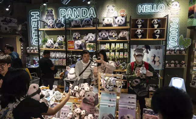 Visitors shop at a panda-themed store in Ocean Park as the Hong Kong-born giant panda twin cubs make their debut appearance to public in Hong Kong, Sunday, Feb. 16, 2025. (AP Photo/Chan Long Hei)