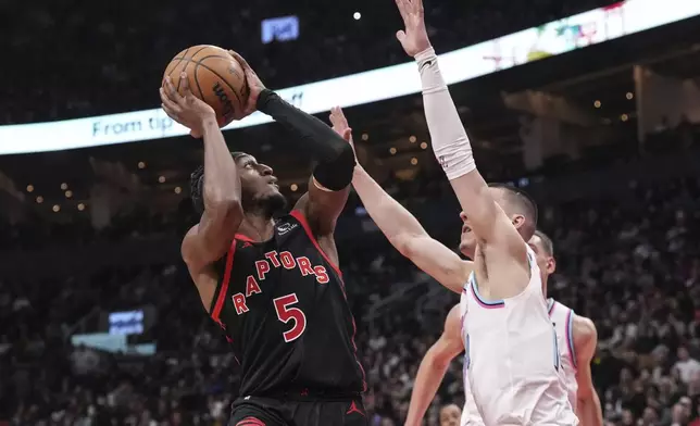 Toronto Raptors' Immanuel Quickley (5) shoots on Miami Heat's Tyler Herro (14) during first half NBA basketball action in Toronto on Friday, February 21, 2025. (Chris Young/The Canadian Press via AP)
