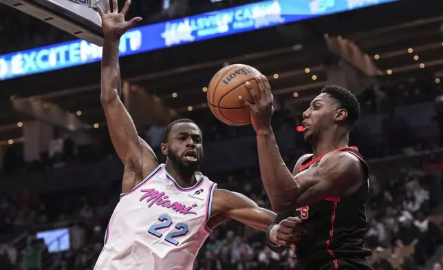 Toronto Raptors' RJ Barrett (9) looks to keep the ball in play in front of Miami Heat's Andrew Wiggins (22) during first half NBA basketball action in Toronto on Friday, February 21, 2025. (Chris Young/The Canadian Press via AP)
