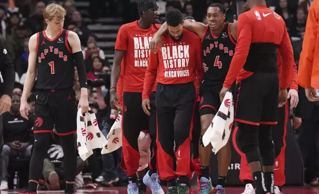 Toronto Raptors' Scottie Barnes (4) is helped off the court during first half NBA basketball action against Miami Heat in Toronto on Friday, February 21, 2025. (Chris Young/The Canadian Press via AP)