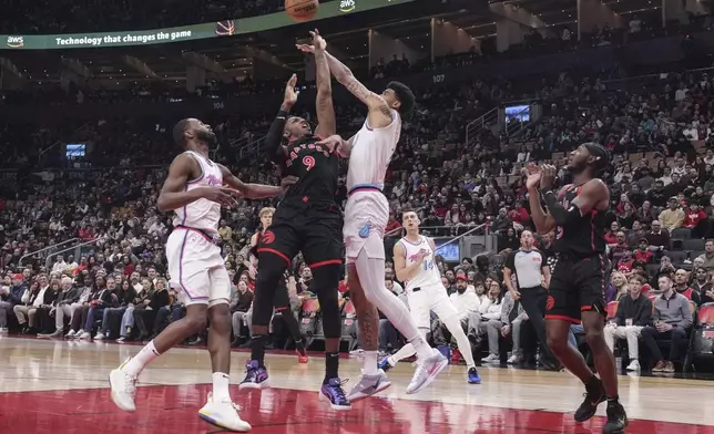 Toronto Raptors' RJ Barrett (9) tries to shoot on Miami Heat's Kel'el Ware, right, as Andrew Wiggins, left, looks on during first half NBA basketball action in Toronto on Friday, February 21, 2025. (Chris Young/The Canadian Press via AP)