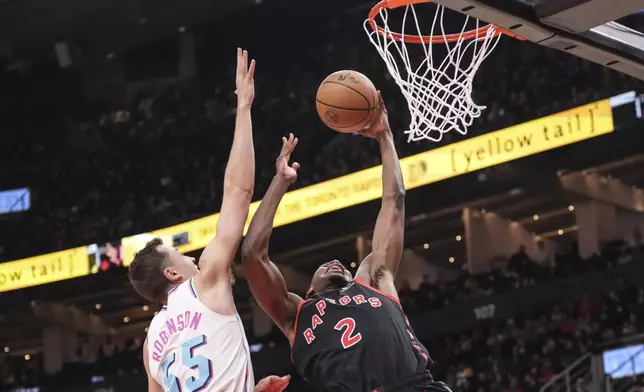Toronto Raptors' Jonathan Mogbo (2) shoots on Miami Heat's Duncan Robinson (55) during first half NBA basketball action in Toronto on Friday, February 21, 2025. (Chris Young/The Canadian Press via AP)