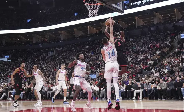 Toronto Raptors' Immanuel Quickley (5) shoots on Miami Heat's Tyler Herro (14) during first half NBA basketball action in Toronto on Friday, February 21, 2025. (Chris Young/The Canadian Press via AP)