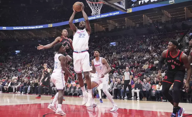 Miami Heat's Andrew Wiggins (22) claims the ball in front of Toronto Raptors' Scottie Barnes (4) during first half NBA basketball action in Toronto on Friday, February 21, 2025. (Chris Young/The Canadian Press via AP)
