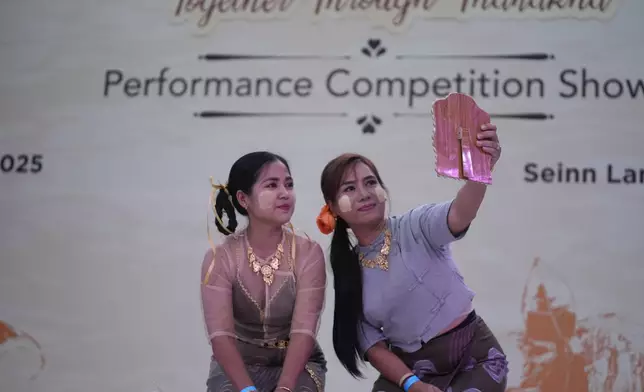 Artists with traditional attire put Thanakha, traditional make-up, on their faces as they take part in performance competition show aiming to submit the traditional culture of Thanakha to UNESCO's Intangible Cultural Heritage of Humanity, Wednesday, Feb.12, 2025 in Yangon, Myanmar. (AP Photo/Thein Zaw)
