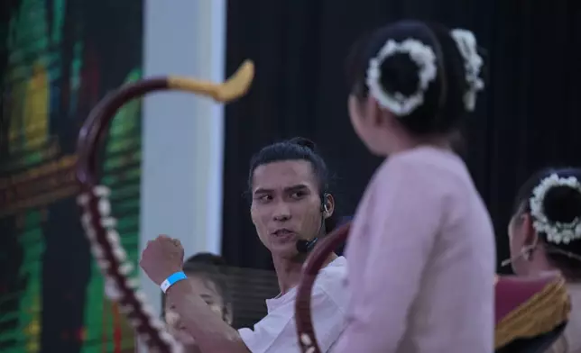 Artist with traditional attire put Thanakha, traditional make-up, on her face as she takes part in performance competition show aiming to submit the traditional culture of Thanakha to UNESCO's Intangible Cultural Heritage of Humanity, Wednesday, Feb.12, 2025 in Yangon, Myanmar. (AP Photo/Thein Zaw)