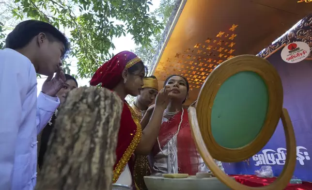Artists with traditional attire put Thanakha, traditional make-up, on their faces as they take part in performance competition show aiming to submit the traditional culture of Thanakha to UNESCO's Intangible Cultural Heritage of Humanity, Wednesday, Feb.12, 2025 in Yangon, Myanmar. (AP Photo/Thein Zaw)