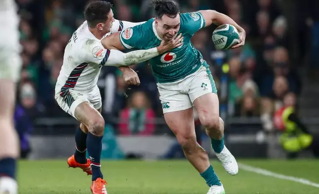 Ireland's James Lowe, right, breaks the tackle of England's Alex Mitchell during the Six Nations rugby union match between Ireland and England at the Aviva Stadium in Dublin, Saturday, Feb. 1, 2025. (AP Photo/Peter Morrison)