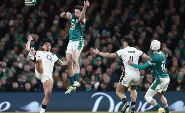 England's Marcus Smith, left, and Ireland's Hugo Keenan battle for the ball during the Six Nations rugby union match between Ireland and England at the Aviva Stadium in Dublin, Saturday, Feb. 1, 2025. (AP Photo/Peter Morrison)