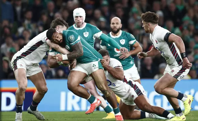 Ireland's Bundee Aki is tackled during the Six Nations rugby union match between Ireland and England at the Aviva Stadium in Dublin, Saturday, Feb. 1, 2025. (AP Photo/Peter Morrison)