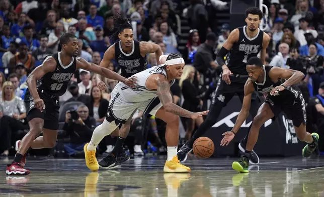 Orlando Magic forward Paolo Banchero, center, goes after a loose ball against, from left, San Antonio Spurs forward Harrison Barnes (40), guard Devin Vassell, center Victor Wembanyama (1) and guard De'Aaron Fox during the second half of an NBA basketball game Saturday, Feb. 8, 2025, in Orlando, Fla. (AP Photo/John Raoux)