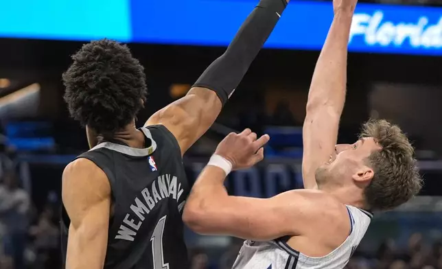 San Antonio Spurs center Victor Wembanyama (1) blocks a shot by Orlando Magic forward Franz Wagner during the first half of an NBA basketball game Saturday, Feb. 8, 2025, in Orlando, Fla. (AP Photo/John Raoux)