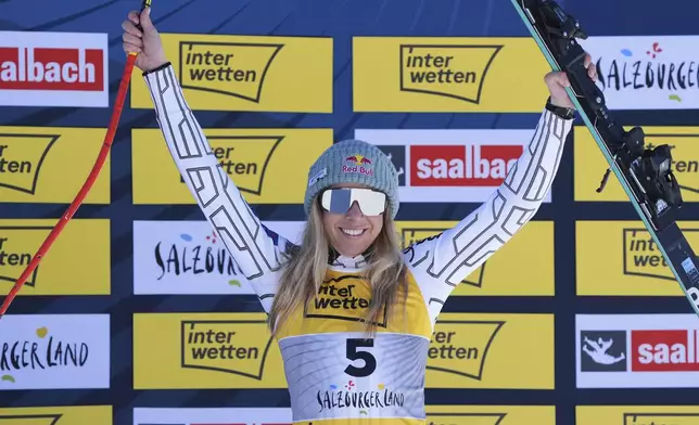 Czech Republic's Ester Ledecka celebrates on the podium after winning the bronze medal in a women's downhill race, at the Alpine Ski World Championships, in Saalbach-Hinterglemm, Austria, Saturday, Feb. 8, 2025. (AP Photo/Giovanni Auletta)