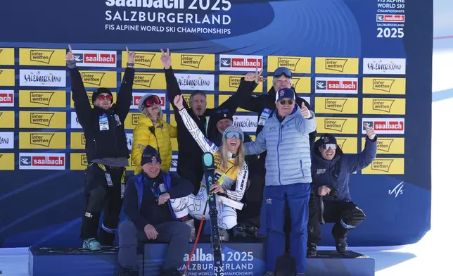 Czech Republic's Ester Ledecka, center, celebrates with the team after winning the bronze medal in a women's downhill race, at the Alpine Ski World Championships, in Saalbach-Hinterglemm, Austria, Saturday, Feb. 8, 2025. (AP Photo/Giovanni Auletta)