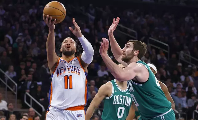 New York Knicks guard Jalen Brunson (11) drives to the basket against Boston Celtics center Luke Kornet, right, during the first half of an NBA basketball game, Saturday, Feb. 8, 2025, in New York. (AP Photo/Noah K. Murray)