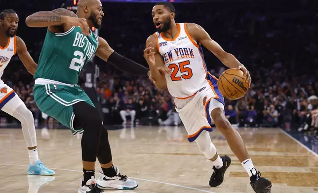 New York Knicks forward Mikal Bridges (25) drives to the basket against Boston Celtics forward Xavier Tillman during the first half of an NBA basketball game, Saturday, Feb. 8, 2025, in New York. (AP Photo/Noah K. Murray)