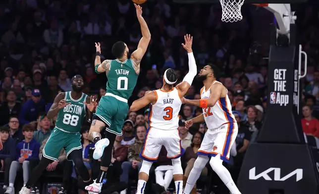 Boston Celtics forward Jayson Tatum (0) drives to the basket against New York Knicks guard Josh Hart (3) and New York Knicks center Karl-Anthony Towns (32) during the first half of an NBA basketball game, Saturday, Feb. 8, 2025, in New York. (AP Photo/Noah K. Murray)