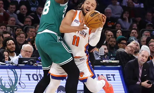 Boston Celtics center Kristaps Porzingis (8) defends against New York Knicks guard Jalen Brunson during the first half of an NBA basketball game, Saturday, Feb. 8, 2025, in New York. (AP Photo/Noah K. Murray)