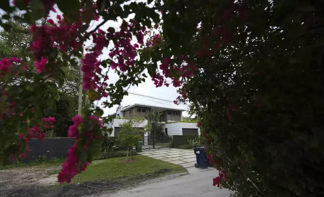 Flowers bloom outside the home where thieves overnight stole a Mercedes and Lamborghini from University of Miami football quarterback Carson Beck, as well as an SUV from his girlfriend, Miami basketball player Hanna Cavinder, Thursday, Feb. 20, 2025, in Miami. (AP Photo/Rebecca Blackwell)
