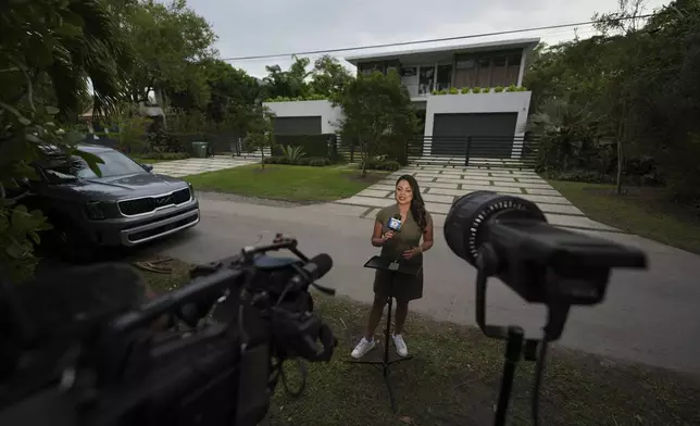 Reporter Bridgette Matter of ABC affiliate WPLG Local 10 speaks to viewers from outside the home where thieves overnight stole a Mercedes and Lamborghini from University of Miami football quarterback Carson Beck, as well as an SUV from his girlfriend, Miami basketball player Hanna Cavinder, Thursday, Feb. 20, 2025, in Miami. (AP Photo/Rebecca Blackwell)