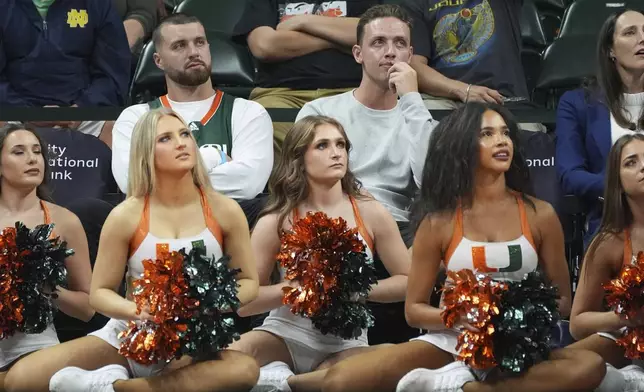 Miami football quarterback Carson Beck, top center, watches the first half of an NCAA college basketball game between Miami and Notre Dame, Thursday, Feb. 20, 2025, in Coral Gables, Fla. (AP Photo/Rebecca Blackwell)