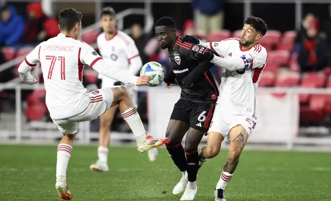 D.C. United midfielder Boris Enow (6) battles for the ball against Toronto FC midfielder Jonathan Osorio, right, and midfielder Markus Cimermancic (71) during the second half of an MLS soccer match, Saturday, Feb. 22, 2025, in Washington. (AP Photo/Nick Wass)