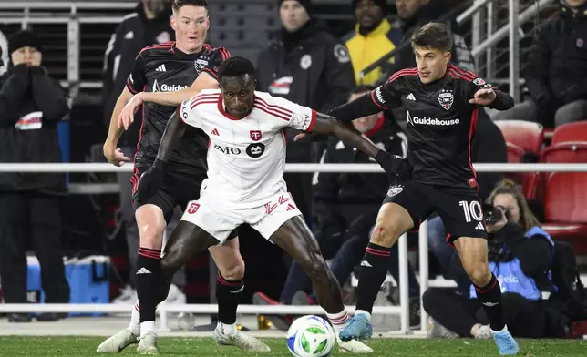 Toronto FC midfielder Richie Laryea, center, battles for the ball against D.C. United defender David Schnegg, left, and midfielder Gabriel Pirani (10) during the second half of an MLS soccer match, Saturday, Feb. 22, 2025, in Washington. (AP Photo/Nick Wass)
