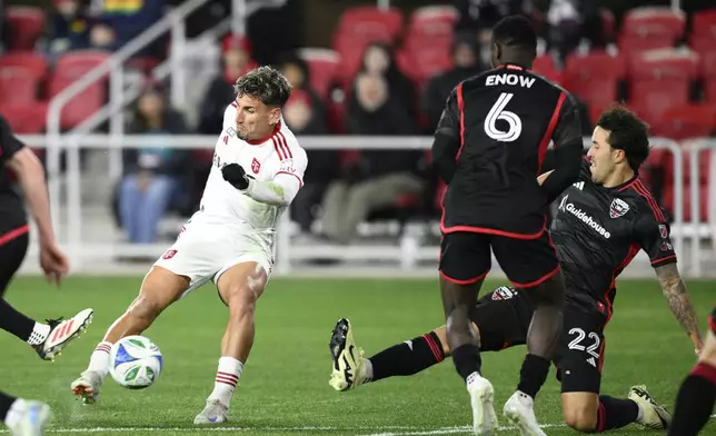Toronto FC Theo Corbeanu, left, kicks the ball against D.C. United midfielder Boris Enow (6) and defender Aaron Herrera (22) during the first half of an MLS soccer match, Saturday, Feb. 22, 2025, in Washington. (AP Photo/Nick Wass)