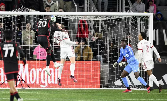 D.C. United forward Christian Benteke (20) heads the ball against Toronto FC defender Kevin Long (5) for a goal during the first half of an MLS soccer match, Saturday, Feb. 22, 2025, in Washington. (AP Photo/Nick Wass)