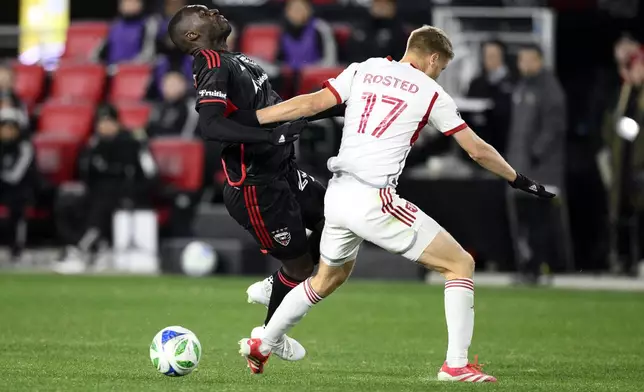 Toronto FC defender Sigurd Rosted (17) grabs D.C. United forward Christian Benteke, left, during the second half of an MLS soccer match, Saturday, Feb. 22, 2025, in Washington. (AP Photo/Nick Wass)