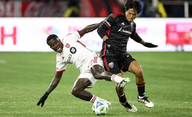 Toronto FC midfielder Richie Laryea, left, battles for the ball against D.C. United midfielder Hosei Kijima, right, during the first half of an MLS soccer match, Saturday, Feb. 22, 2025, in Washington. (AP Photo/Nick Wass)