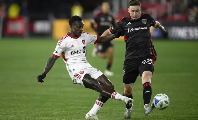 Toronto FC midfielder Richie Laryea, left, kicks the ball against D.C. United defender David Schnegg (28) during the first half of an MLS soccer match, Saturday, Feb. 22, 2025, in Washington. (AP Photo/Nick Wass)