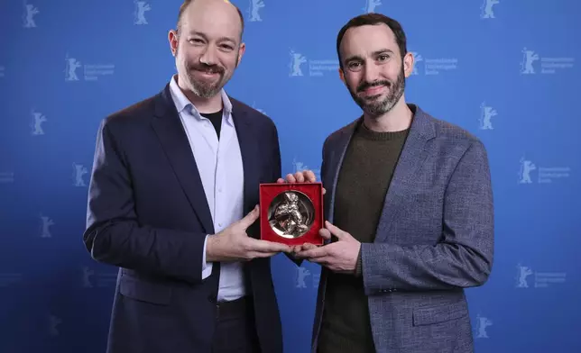 US director Brandon Kramer, right, and US director Lance Kramer pose with the Berlinale Documentary Award during the winner's photocall at the International Film Festival, Berlinale, in Berlin, Saturday, Feb. 22, 2025. (Ronny Hartmann/Pool via AP)