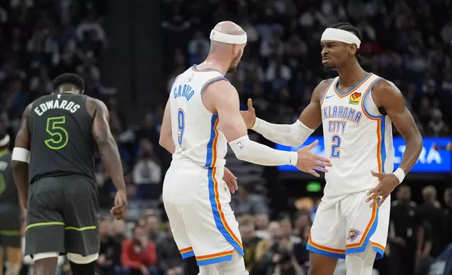 Oklahoma City Thunder guards Alex Caruso (9) and Shai Gilgeous-Alexander (2) celebrate during the second half of an NBA basketball game against the Minnesota Timberwolves, Sunday, Feb. 23, 2025, in Minneapolis. (AP Photo/Abbie Parr)