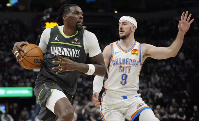 Minnesota Timberwolves center Naz Reid (11) works toward the basket as Oklahoma City Thunder guard Alex Caruso (9) defends during the first half of an NBA basketball game, Sunday, Feb. 23, 2025, in Minneapolis. (AP Photo/Abbie Parr)