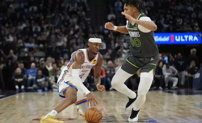 Oklahoma City Thunder guard Shai Gilgeous-Alexander (2) works toward the basket as Minnesota Timberwolves guard Terrence Shannon Jr. (00) defends during the second half of an NBA basketball game, Sunday, Feb. 23, 2025, in Minneapolis. (AP Photo/Abbie Parr)