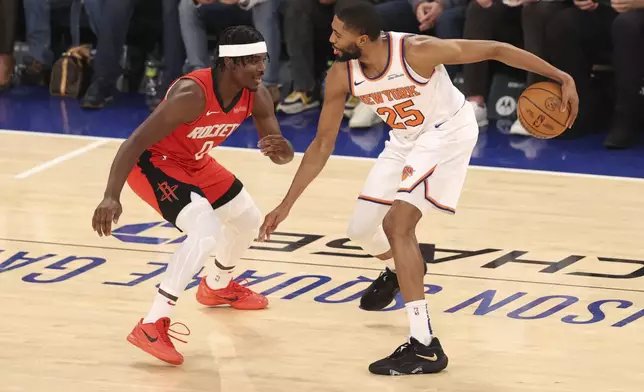 New York Knicks' Mikal Bridges (25) dribbles the ball against Houston Rockets' Aaron Holiday during the first half of an NBA basketball game Monday, Feb. 3, 2025, in New York. (AP Photo/Pamela Smith)