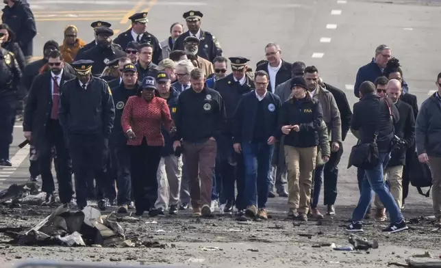 Pennsylvania Gov. Josh Shapiro, Philadelphia Mayor Cherelle Parker and other officials view the aftermath of a fatal small plane crashed in Philadelphia, Monday, Feb. 3, 2025. (AP Photo/Matt Rourke)