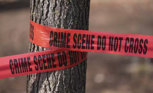 Crime scene tape is wrapped around a tree in the aftermath of a fatal small plane crashed in Philadelphia, Monday, Feb. 3, 2025. (AP Photo/Matt Rourke)