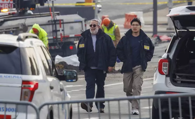 NTSB employees walk through the scene of medical jet crash Monday morning Feb. 3, 2025, in Philadelphia. (Alejandro A. Alvarez/The Philadelphia Inquirer via AP)