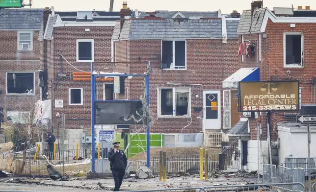 Police walk through the scene of a medical jet crash Monday morning Feb. 3, 2025, in Philadelphia. (Alejandro A. Alvarez/The Philadelphia Inquirer via AP)