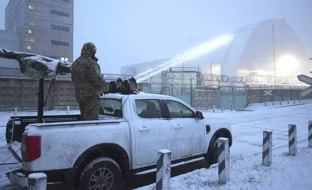 Ukrainian serviceman stands on a vehicle with anti-aircraft gun after a drone attack at the former Chernobyl nuclear power plant, Ukraine, Friday, Feb. 14, 2025. (AP Photo/Efrem Lukatsky)