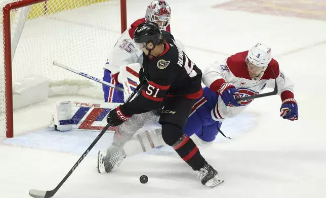 Ottawa Senators' Cole Reinhardt (51) and Montreal Canadiens' Mike Matheson (8) collide in front of Montreal Canadiens' goaltender Sam Montembeault (35) during first period NHL hockey action in Ottawa on Saturday, Feb. 22, 2025. (Patrick Doyle/The Canadian Press via AP)
