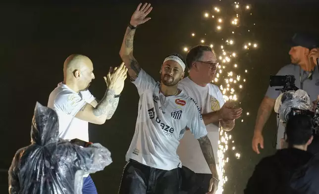 Brazilian soccer player Neymar, center, waves to fans during his presentation ceremony after signing a six-month contract with Santos FC at Vila Belmiro Stadium in Santos, Brazil, Friday, Jan. 31, 2025. (AP Photo/Andre Penner)