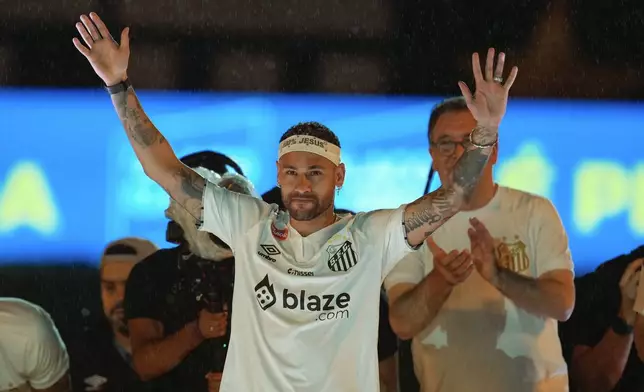 Brazilian soccer player Neymar waves to fans during his presentation ceremony after signing a six-month contract with Santos FC at Vila Belmiro Stadium in Santos, Brazil, Friday, Jan. 31, 2025. (AP Photo/Andre Penner)