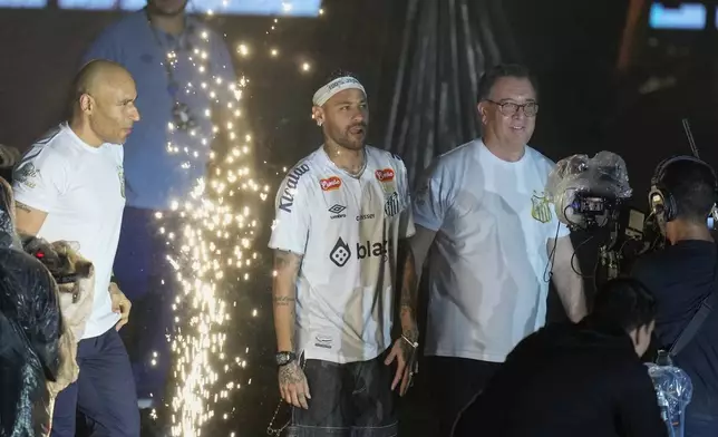 Brazilian soccer player Neymar, center, enters the pitch during his presentation ceremony after signing a six-month contract with Santos FC at Vila Belmiro Stadium in Santos, Brazil, Friday, Jan. 31, 2025. (AP Photo/Andre Penner)