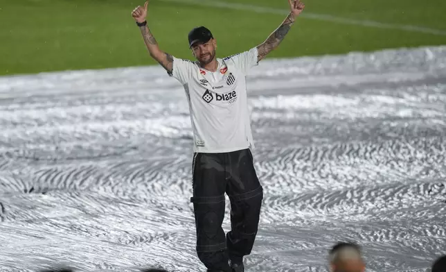 Brazilian soccer player Neymar waves to fans during his presentation ceremony after signing a six-month contract with Santos FC at Vila Belmiro Stadium in Santos, Brazil, Friday, Jan. 31, 2025. (AP Photo/Andre Penner)