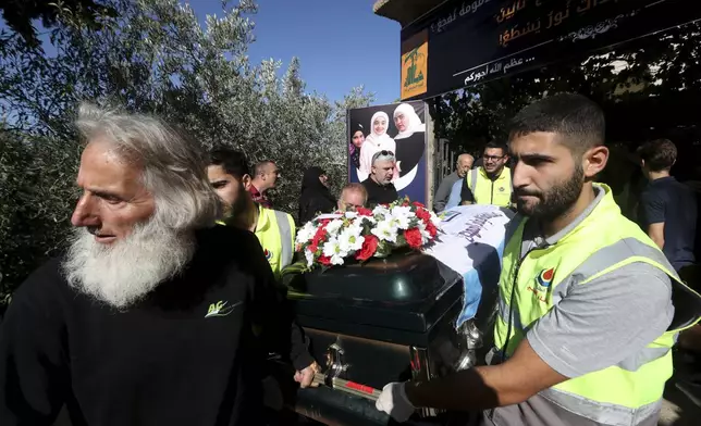 FILE - Relatives of Samira Ayoub, and her three granddaughters, Rimas, 14; Taline, 12, and Liane, 10, who were killed by an Israeli airstrike, carry one of their coffins during a funeral procession in the town of Ainata, a village in south Lebanon near the border with Israel, Tuesday, Nov. 7, 2023. (AP Photo/Mohammed Zaatari, File)