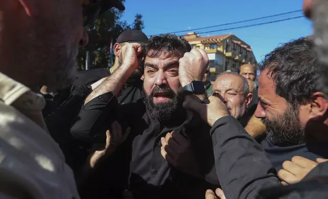 FILE - Mahmoud Adnan Chour, center, the father of three girls, Rimas, 14; Taline, 12, and Liane, 10, who were killed with their grandmother Samira Ayoub, by an Israeli airstrike, weeps during their funeral procession in the town of Ainata, a Lebanese village near the border with Israel, Tuesday, Nov. 7, 2023. (AP Photo/Mohammed Zaatari, File)